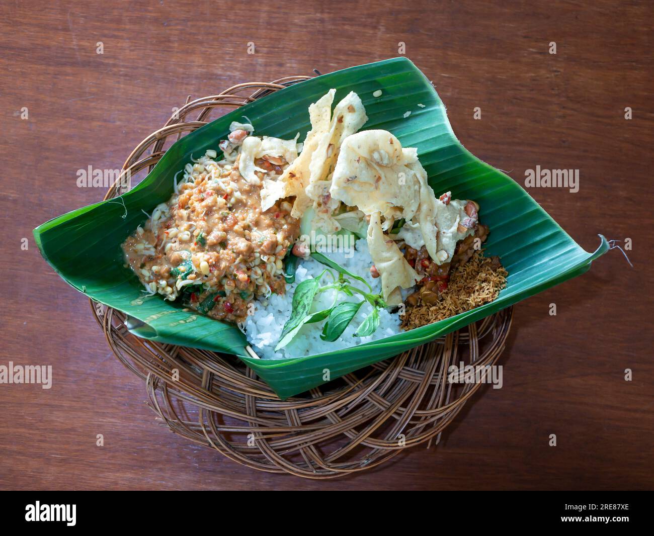 Pecel Pincuk, un cibo tradizionale giavanese, servito su foglie di banana, uno dei pacchetti alimentari ecologici. Foto Stock