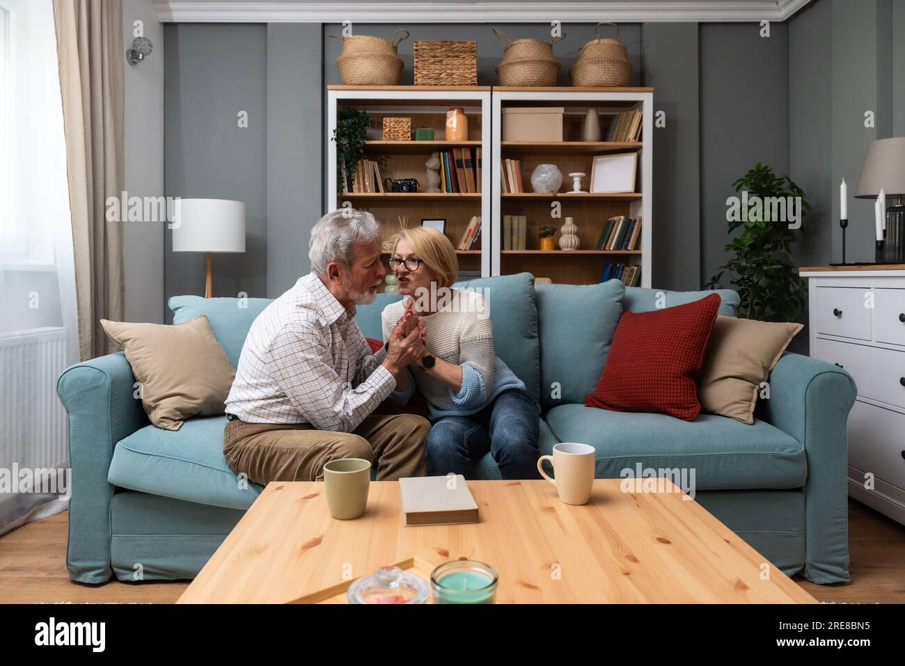Coppia anziana, colloquio serio e comunicazione circa i problemi e le edizioni di Unione mentre sedendosi sul divano nel paese. Uomo e donna maturi che parlano e d Foto Stock