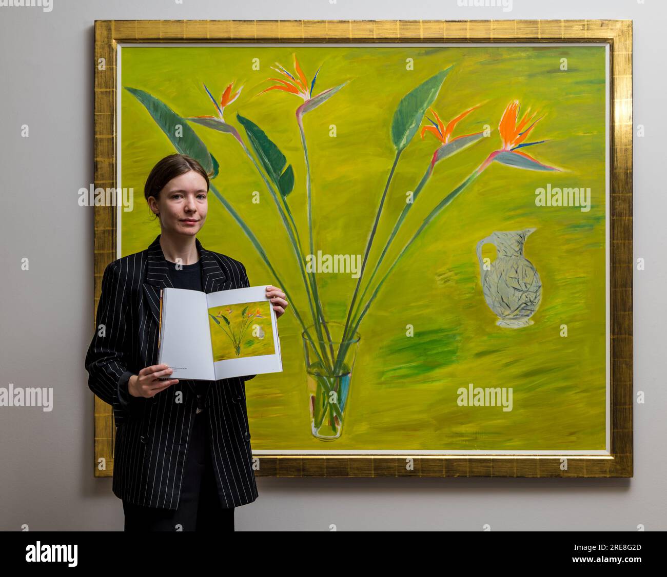 The Scottish Gallery, Edimburgo, Scozia, Regno Unito, 26 luglio 2023, Edinburgh Art Festival: Una nuova mostra chiamata Wonder Women presenta opere dell'artista di fama internazionale Elizabeth Blackadder come parte dell'Edinburgh Art Festival. Nella foto: Un membro dello staff della galleria con un dipinto di Elizabeth Blackadder e il catalogo della mostra. Crediti: Sally Anderson/Alamy Live News Foto Stock