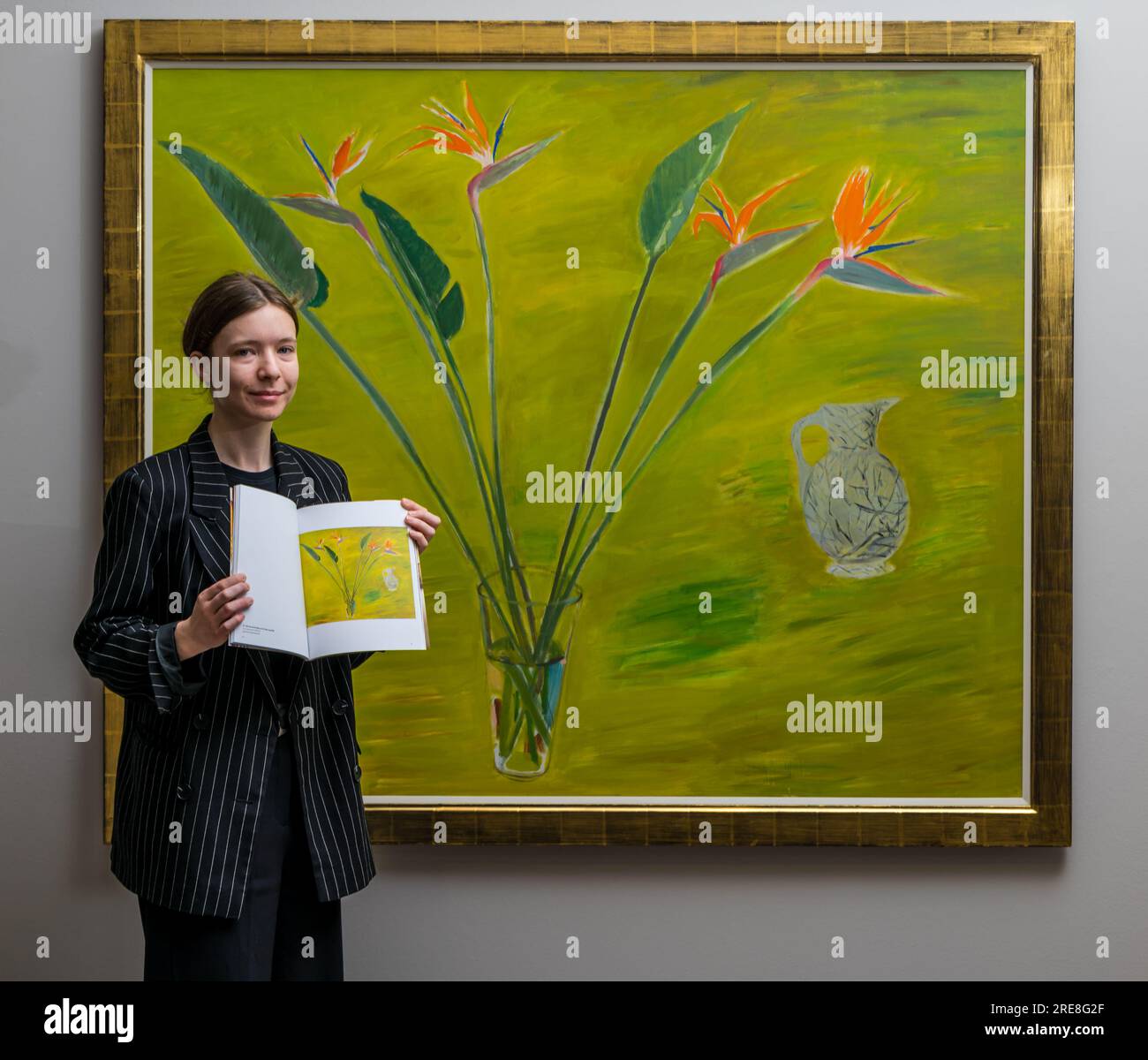 The Scottish Gallery, Edimburgo, Scozia, Regno Unito, 26 luglio 2023, Edinburgh Art Festival: Una nuova mostra chiamata Wonder Women presenta opere dell'artista di fama internazionale Elizabeth Blackadder come parte dell'Edinburgh Art Festival. Nella foto: Un membro dello staff della galleria con un dipinto di Elizabeth Blackadder e il catalogo della mostra. Crediti: Sally Anderson/Alamy Live News Foto Stock