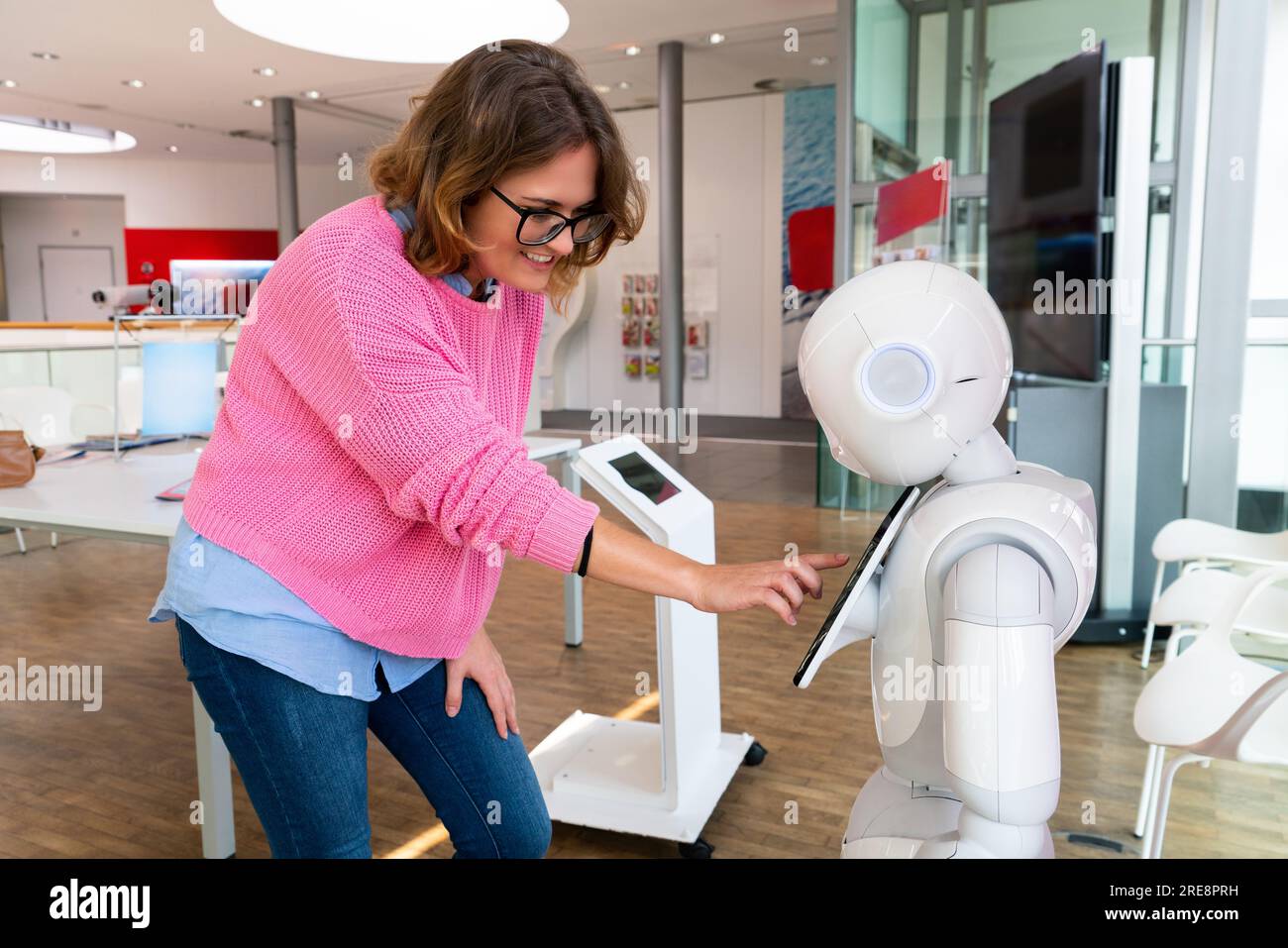 Una donna comunica con un consulente robotico. Foto Stock