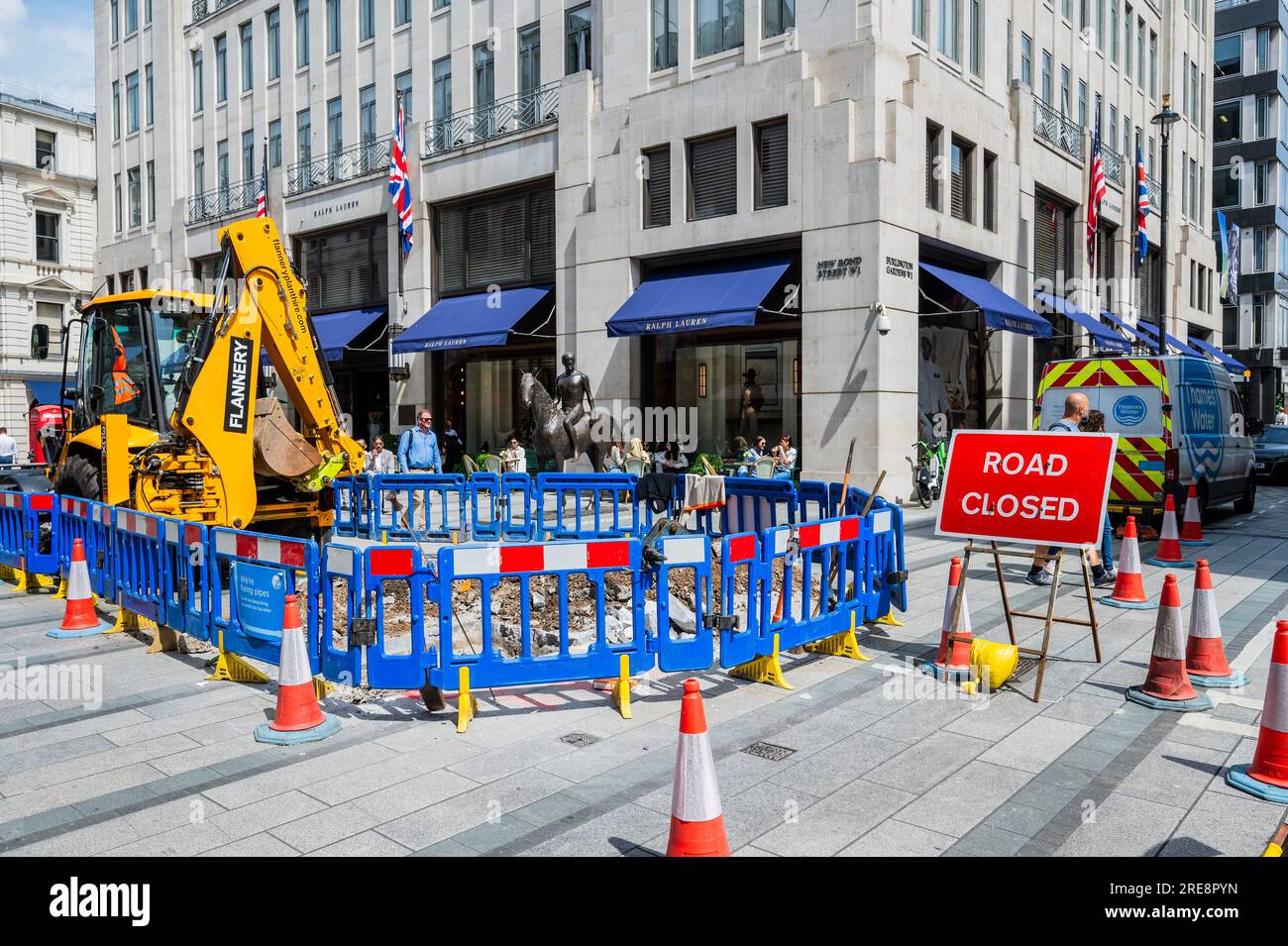 Londra, Regno Unito. 26 luglio 2023. Stiamo riparando tubi dice il cartello sulla recinzione intorno a un buco scavato da Thames Water in Old Bond Street. La mancanza di attività è una metafora dei problemi dell'azienda e dei lenti progressi nella riparazione delle perdite. Crediti: Guy Bell/Alamy Live News Foto Stock