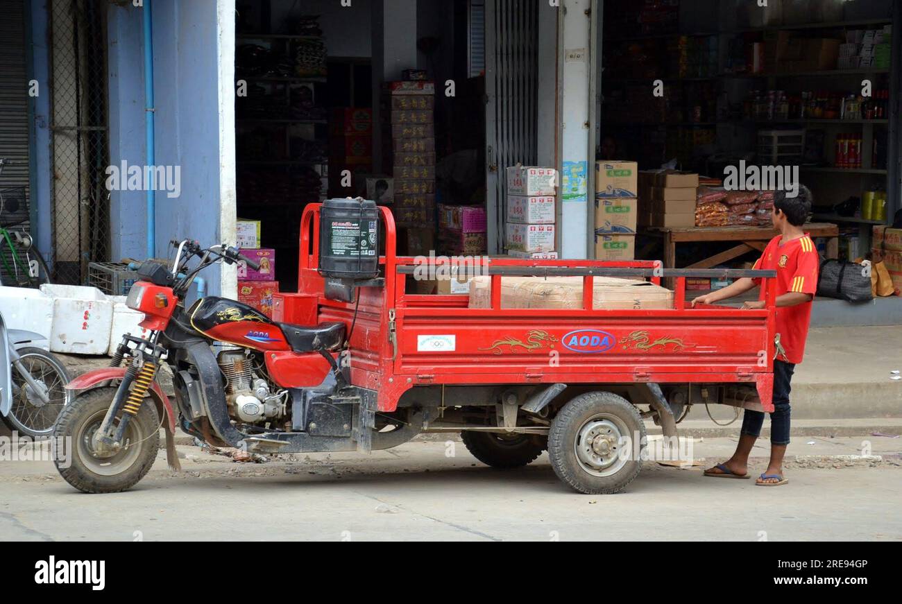 L'uomo scarica un carrello per motociclette, le persone spostano merci per la vendita, le persone lavorano, Tachileik, tachilek, città del Myanmar, People, asia, Sud Est asiatico, città di confine, Stato Shan, Myanmar orientale, birmania Foto Stock