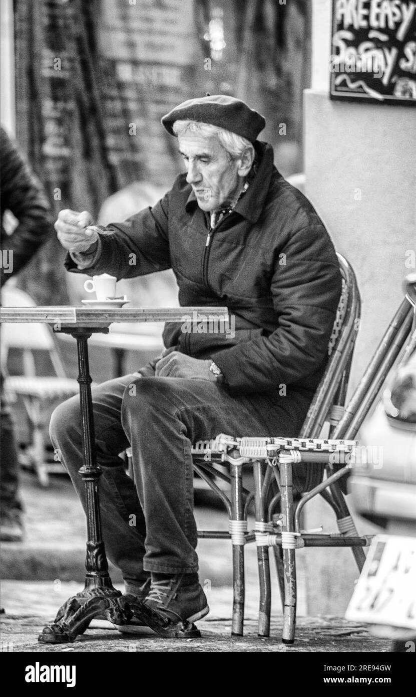 Un artista di Montmarte che beve il suo caffè al mattino presto prima di andare a lavorare dipingendo scene parigine per i turisti. Francia. Foto Stock