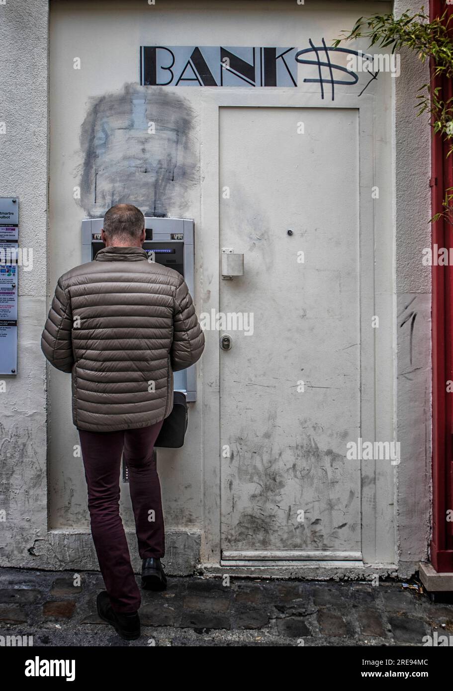 Un uomo alla bancomat di una banca che ritira denaro. Parigi, Francia. Foto Stock
