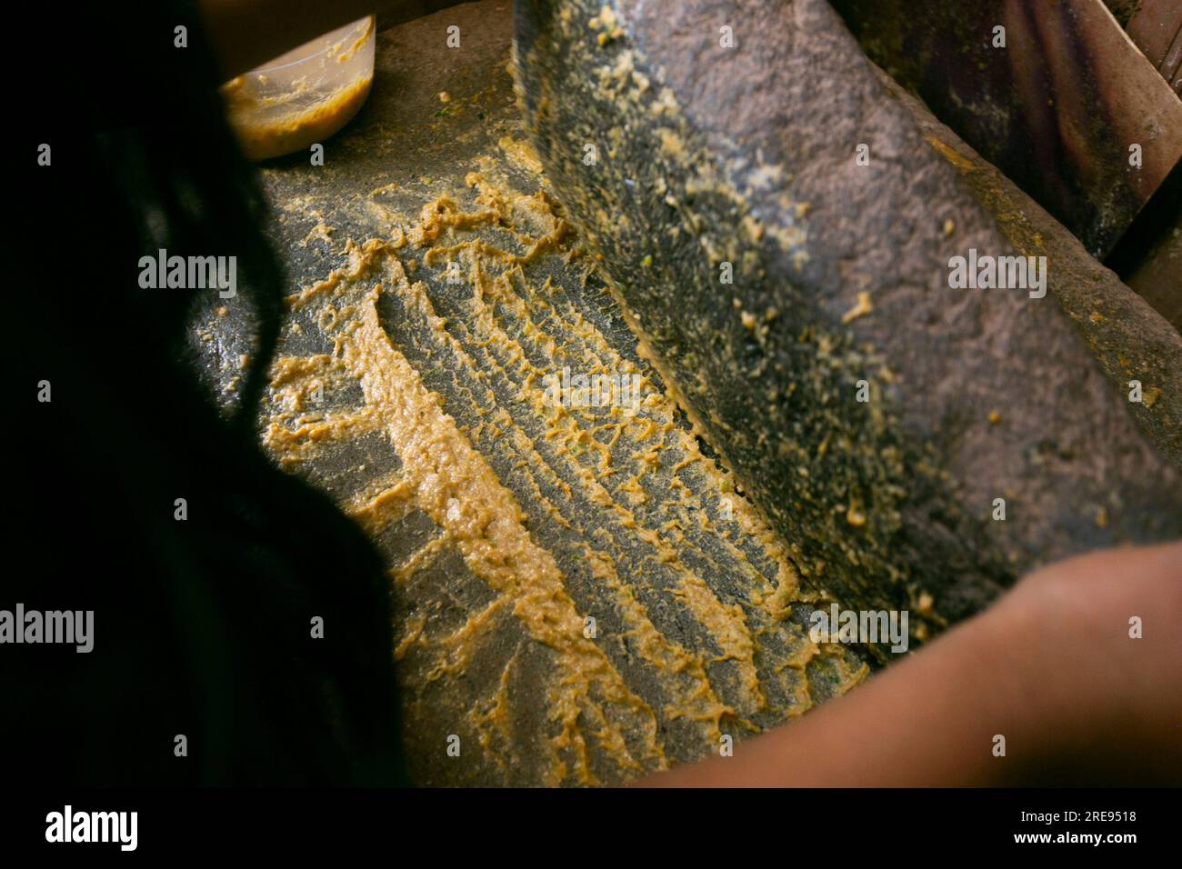 Preparazione del peperoncino giallo peruviano, chiamato anche salsa aji amarillo con un mulino nella città di Cusco in Perù. Foto Stock