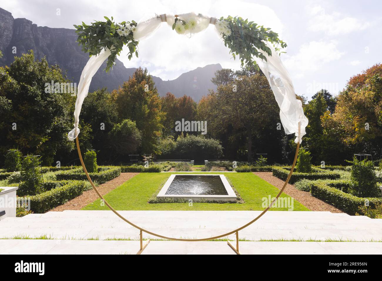 Arco decorativo per matrimoni e laghetto nel giardino soleggiato Foto Stock
