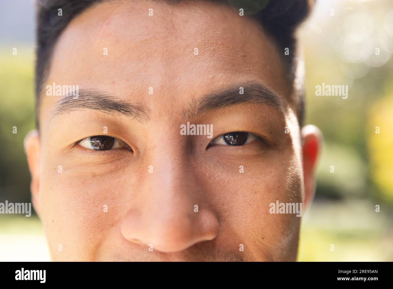 Ritratto ravvicinato di un uomo asiatico felice sorridente in un giardino soleggiato Foto Stock