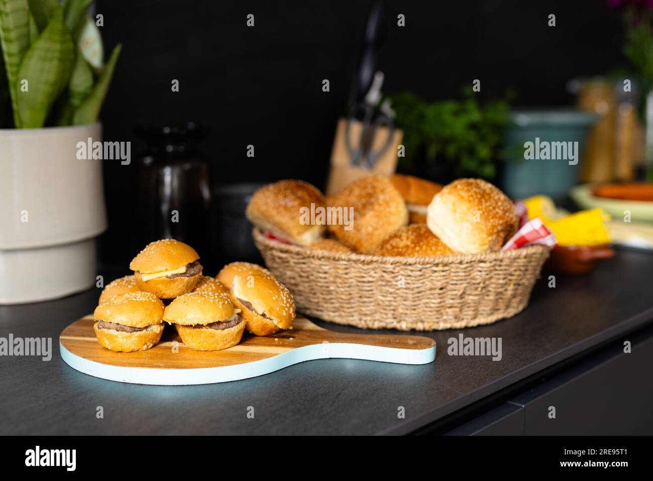 Primo piano del cestino con panini e mini hamburger sul ripiano della cucina Foto Stock