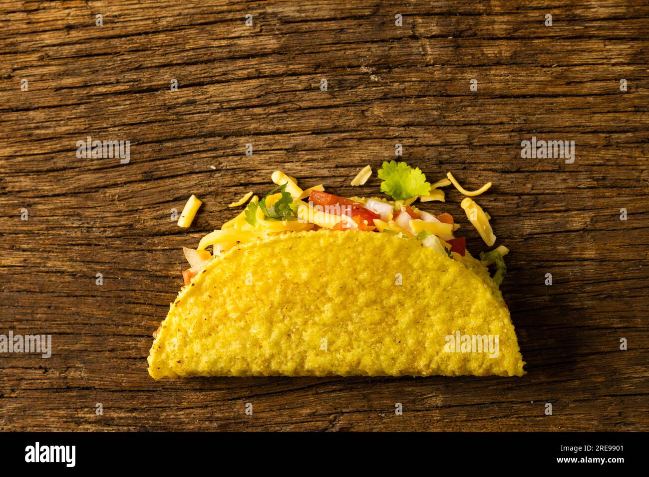 Primo piano del taco ripieno di formaggio e carne su un tavolo di legno Foto Stock