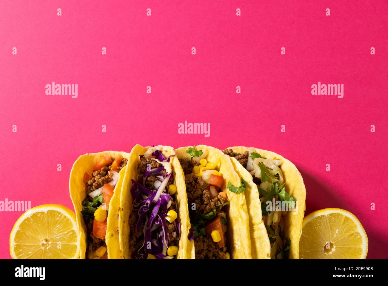 Direttamente sopra lo shot di tacos con fette di limone su sfondo rosa, spazio di copia Foto Stock