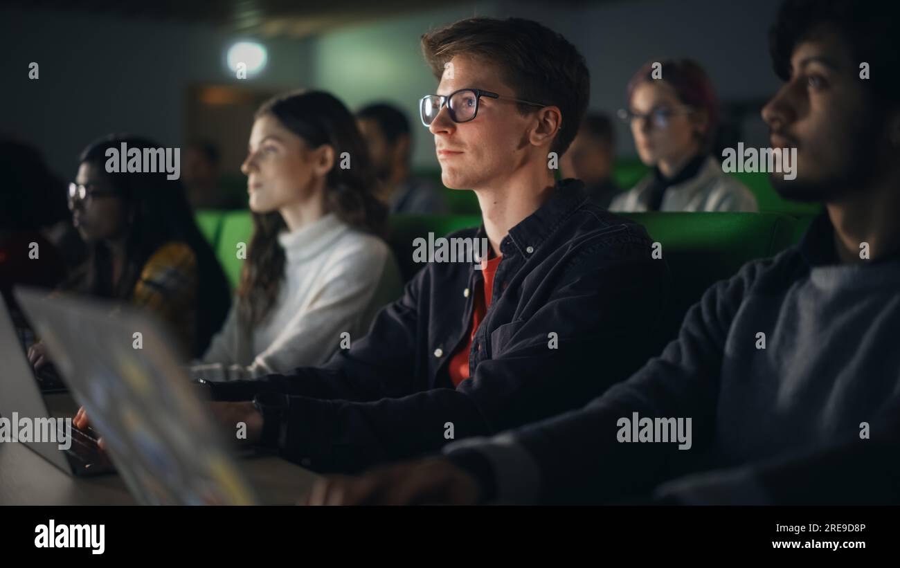 Giovani studenti intelligenti che studiano all'università con diversi compagni di classe multietnici. Gli studiosi hanno una conversazione in College Room. Applicazione delle conoscenze Foto Stock