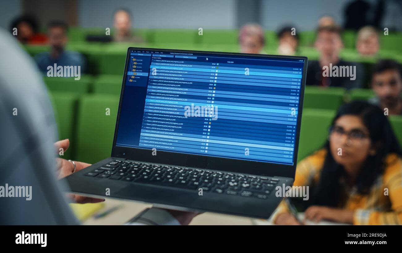 Primo piano di un professore universitario che utilizza un computer portatile con materiali di intelligenza artificiale. Insegnante femminile che tiene una lezione Foto Stock