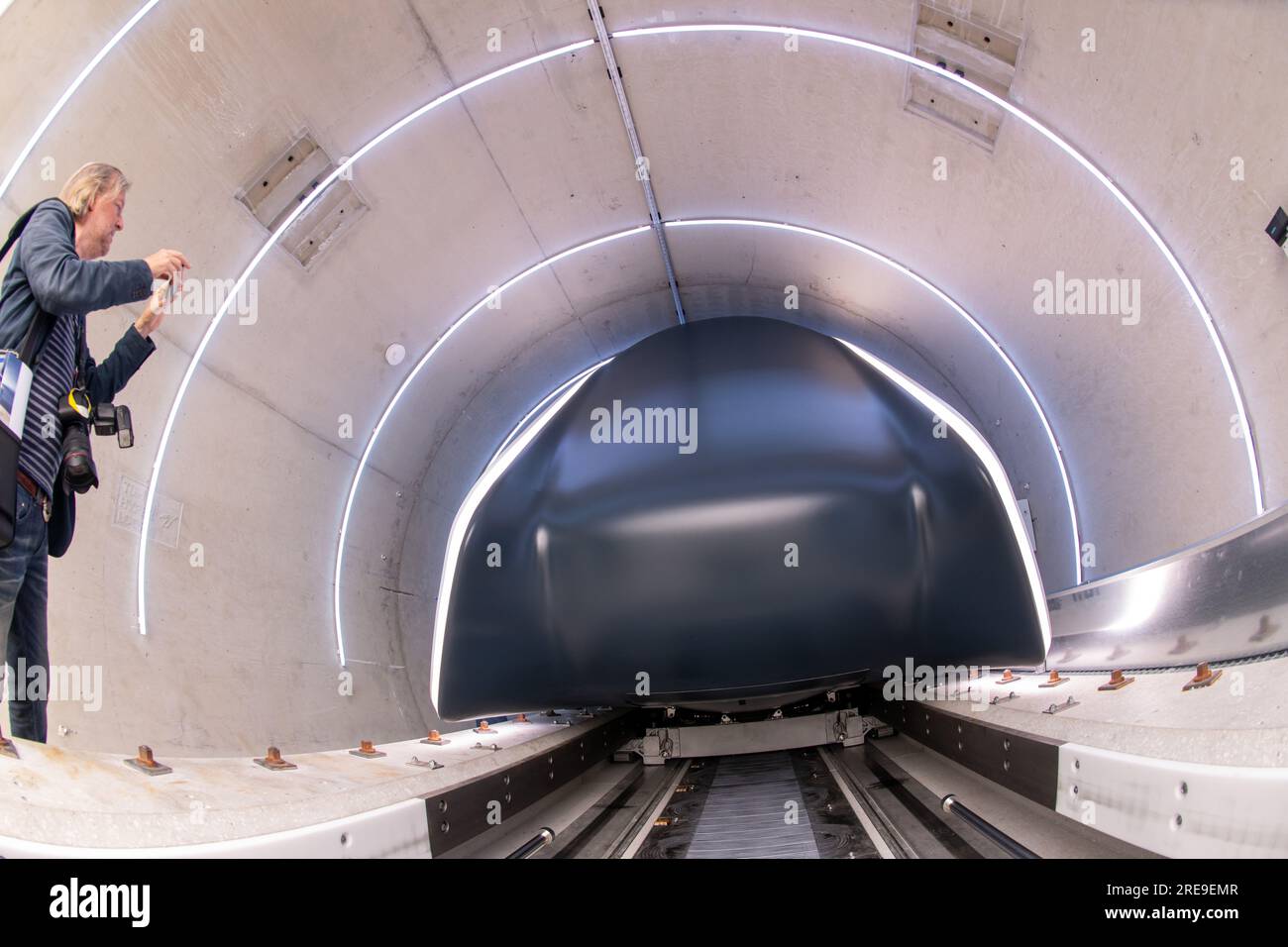 Ottobrunn, Germania. 26 luglio 2023. Il tubo del binario di prova Hyperloop con la sua cabina di trasporto è aperto per la visione prima che inizi l'apertura. Il nuovo tracciato di prova Hyperloop presso l'Università tecnica di Monaco (TUM) comprende un tubo del vuoto lungo 24 metri in calcestruzzo e un veicolo passeggeri di dimensioni normali - è il primo in Europa ad essere completamente certificato per il funzionamento dei passeggeri, secondo TUM. Crediti: Peter Kneffel/dpa/Alamy Live News Foto Stock