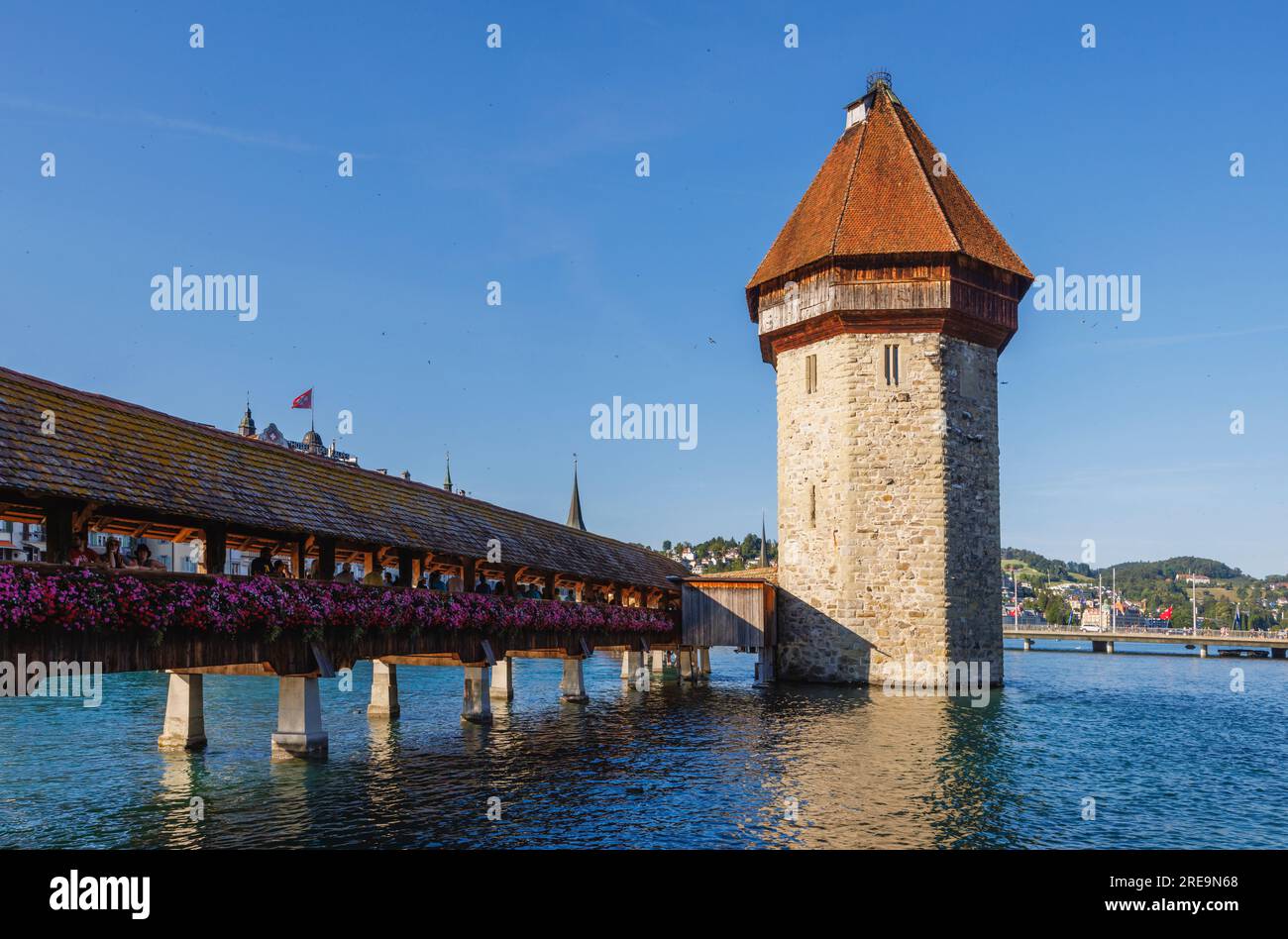 Lo storico ponte della cappella in legno (Kapellbrucke) che attraversa il fiume Reuss e la pietra Wasserturm a Lucerna (Lucerna), una città della Svizzera centrale Foto Stock