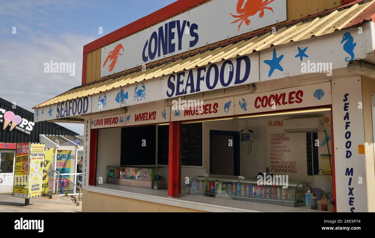 Porthcawl, Bridgend, Galles - 19 giugno 2023: Insegne e cartelloni pubblicitari dai colori vivaci continuano a pubblicizzare cibo e bevande in vendita Foto Stock