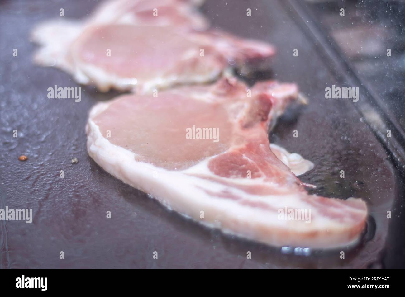 Bistecca di maiale su un barbecue fatto in casa che è sopra un fornello, concetto di preparare il cibo a casa. Foto Stock
