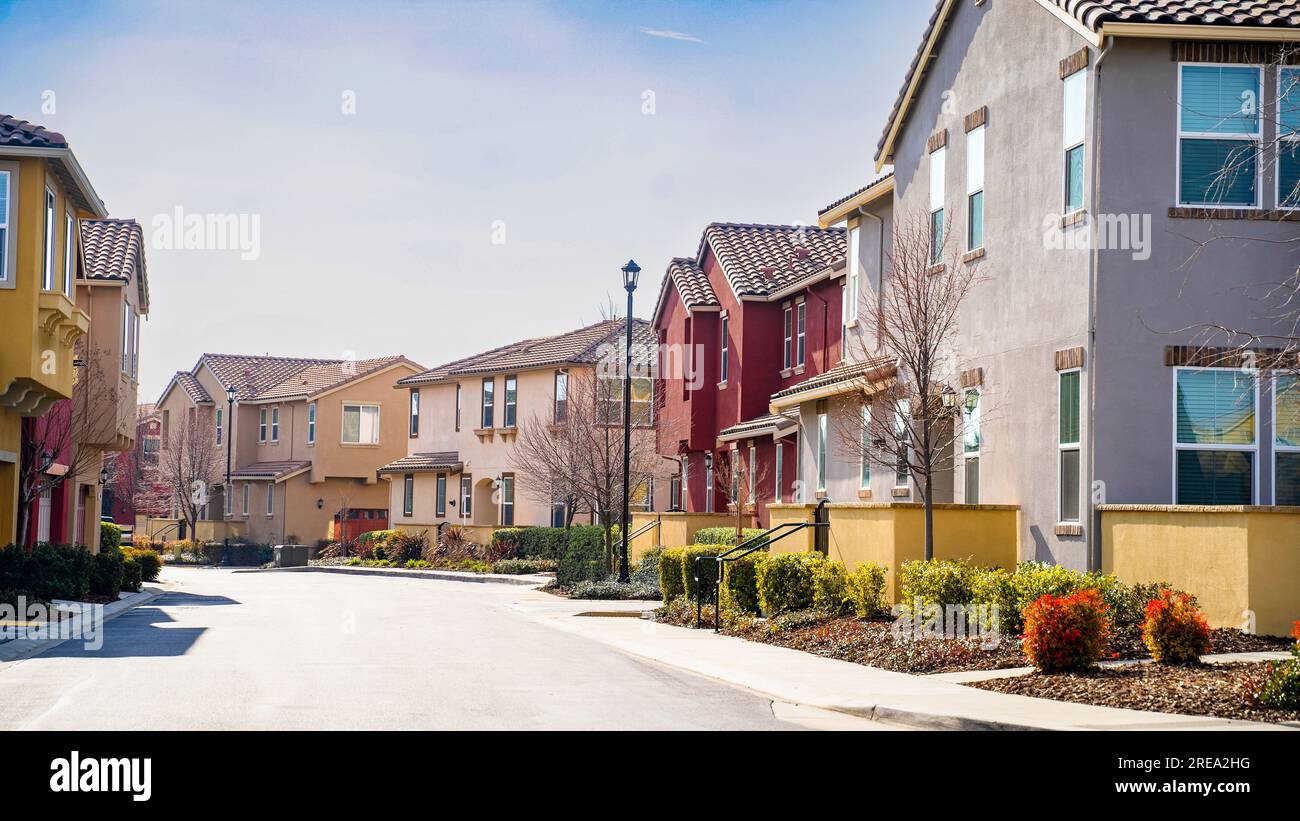 Strada di quartiere periferico in California. Case multicolori e cielo limpido Foto Stock