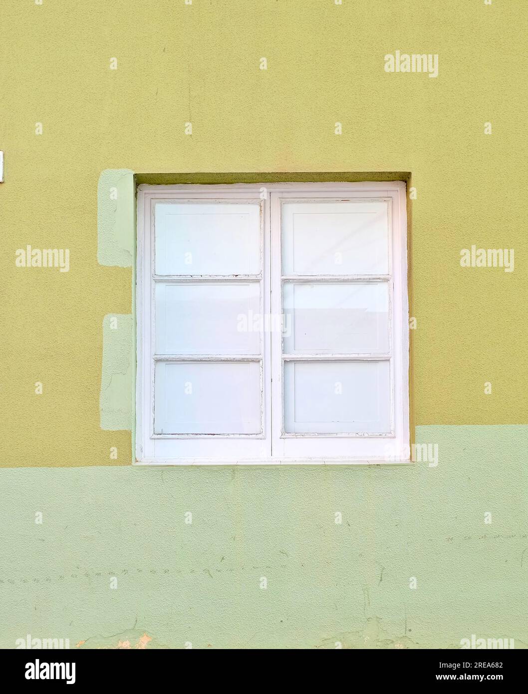 Minimale, semplice, una finestra chiusa bianca in una parete verde a due tonalità. Foto Stock