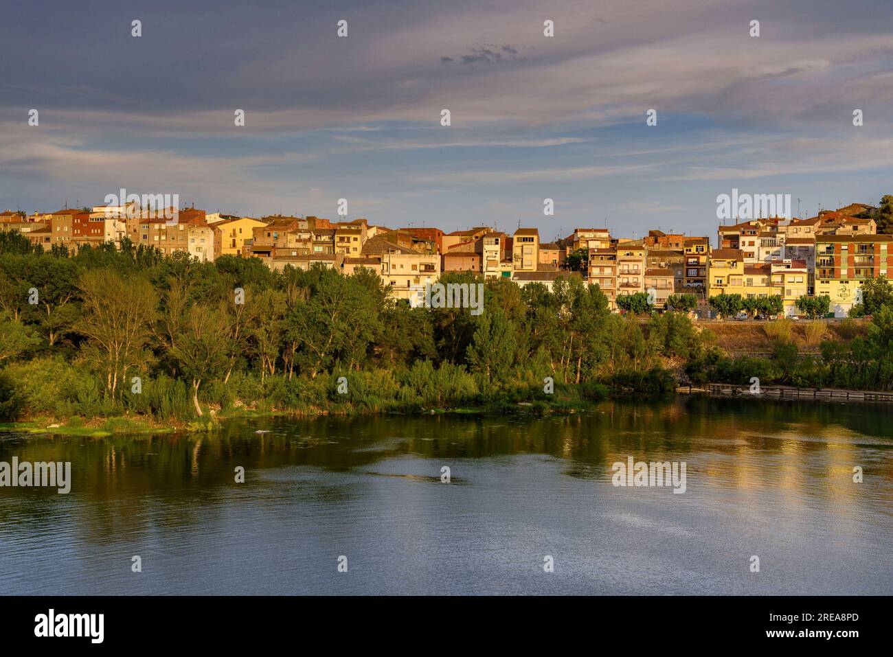 Villaggio di Flix sulle rive del fiume Ebro, visto dalla diga artificiale di Flix al tramonto (Ribera d'Ebre, Tarragona, Catalogna, Spagna) Foto Stock