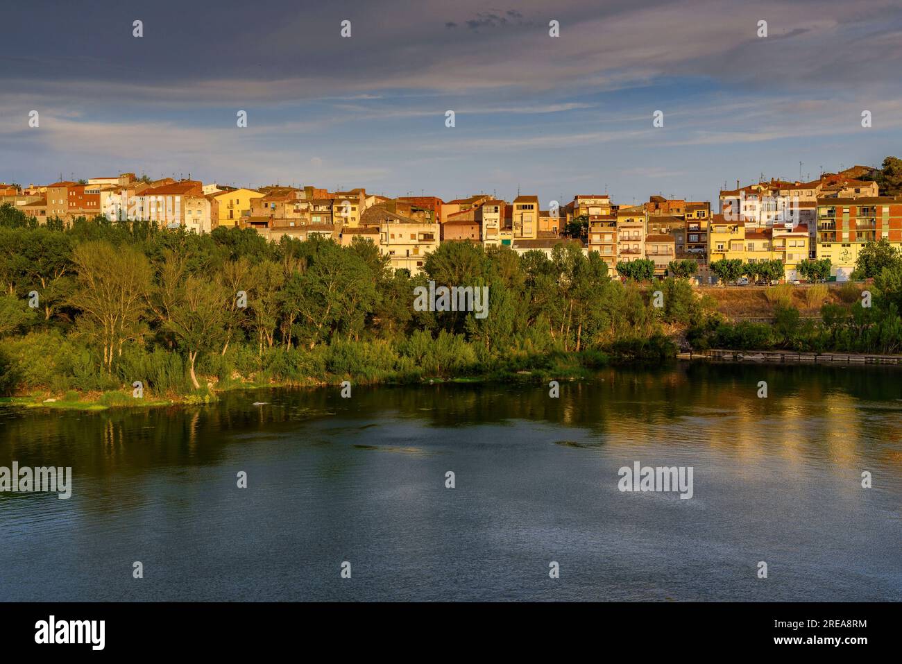 Villaggio di Flix sulle rive del fiume Ebro, visto dalla diga artificiale di Flix al tramonto (Ribera d'Ebre, Tarragona, Catalogna, Spagna) Foto Stock