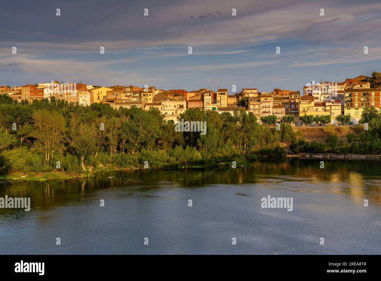 Villaggio di Flix sulle rive del fiume Ebro, visto dalla diga artificiale di Flix al tramonto (Ribera d'Ebre, Tarragona, Catalogna, Spagna) Foto Stock