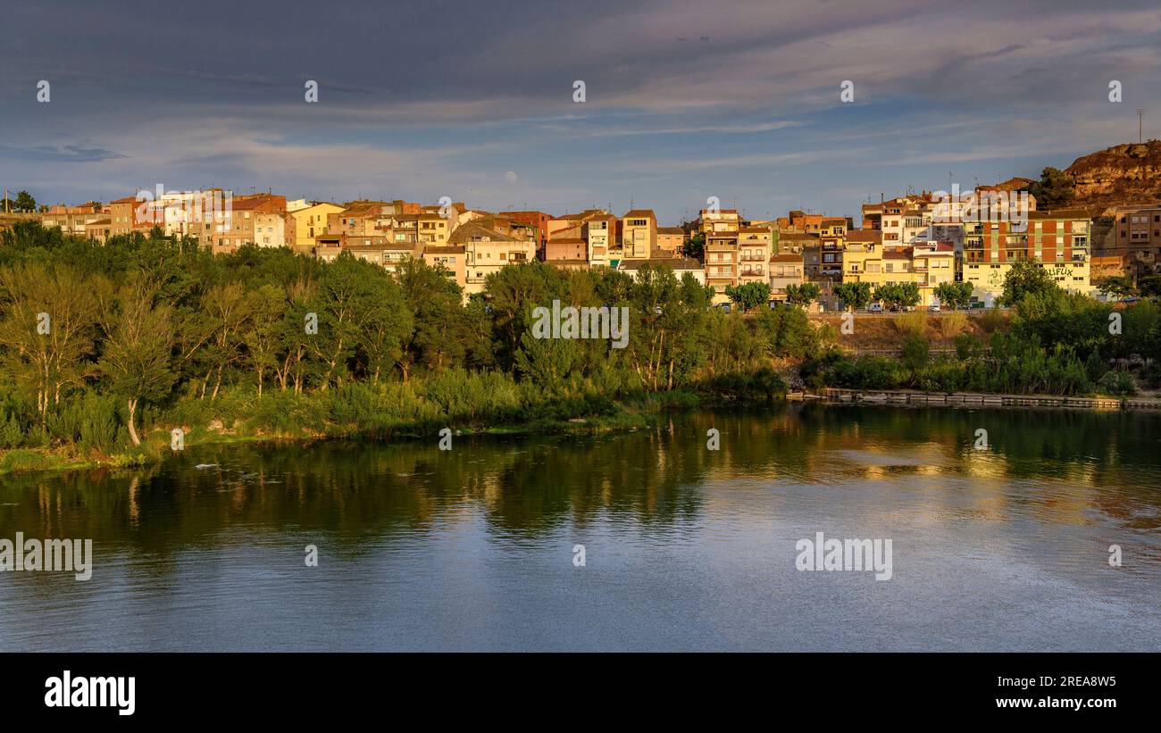 Villaggio di Flix sulle rive del fiume Ebro, visto dalla diga artificiale di Flix al tramonto (Ribera d'Ebre, Tarragona, Catalogna, Spagna) Foto Stock