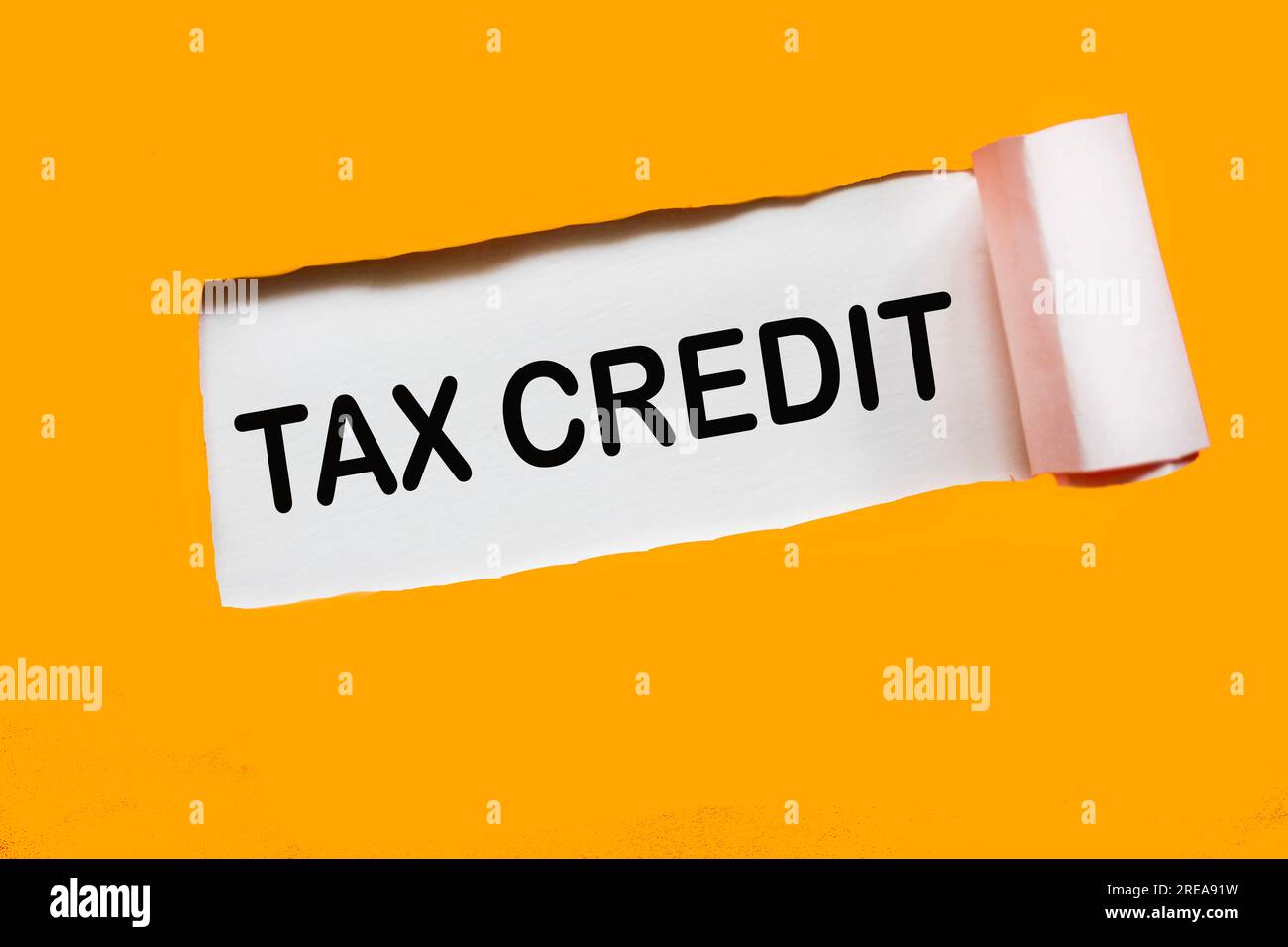 Nota con carta arancione strappata e testo CREDITO D'IMPOSTA. Foto Stock