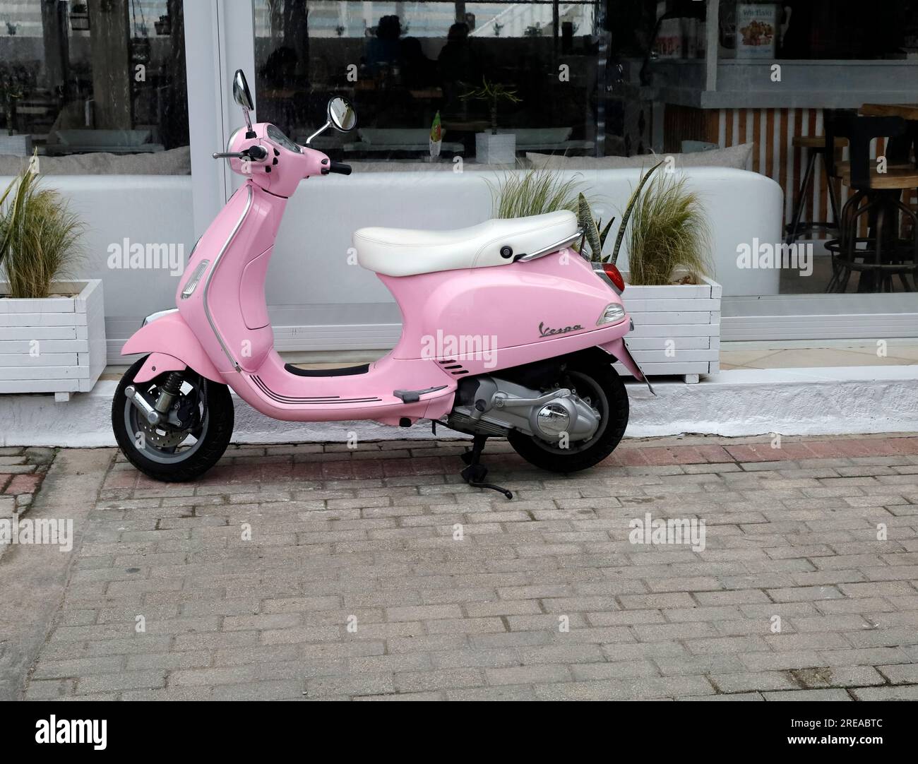 Scooter Vespa rosa parcheggiato accanto alla strada, all'isola Agistri, al gruppo delle isole Saroniche. Estate 2023 Foto Stock