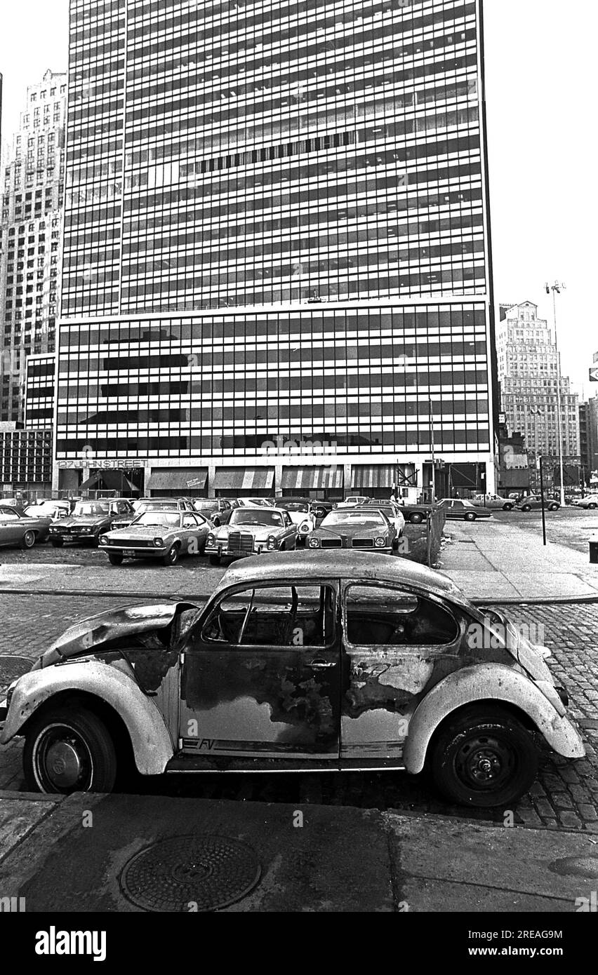 AJAXNETPHOTO. LUGLIO 1975. NEW YORK, USA. - LOWER MANHATTAN - UN'AUTO VOLKSWAGEN BRUCIATA ABBANDONATA SU WATER STREET CHE GUARDA VERSO IL 127 DI JOHN STREET. FOTO:JONATHAN EASTLAND/AJAXREF:750047 17A 30 Foto Stock
