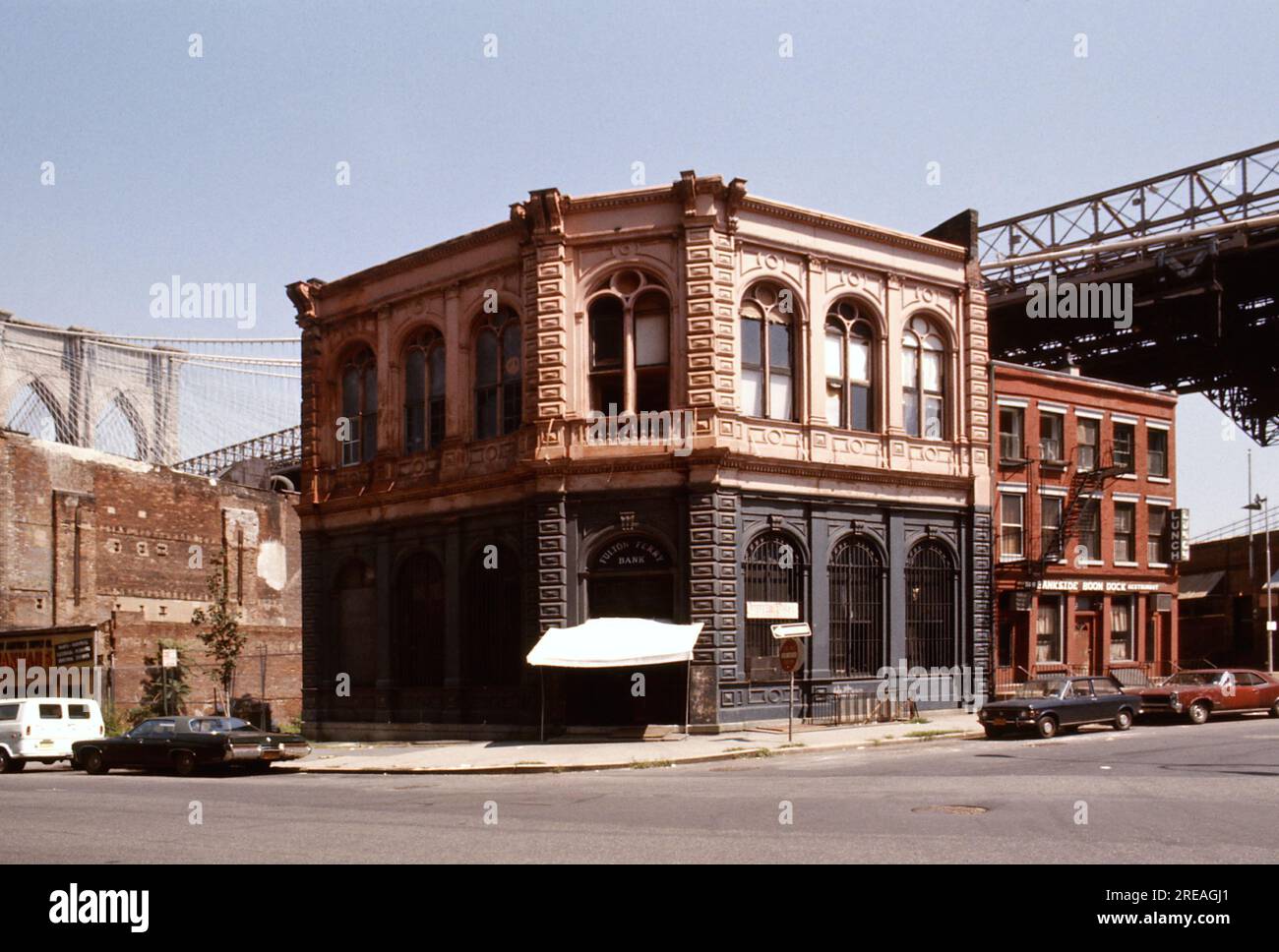 AJAXNETPHOTO. LUGLIO 1975. BROOKLYN, NEW YORK, USA. - OLD BANK - BROOKLYN BRIDGE TOWER CHE EMERGE DIETRO EDIFICI COMMERCIALI DEL XIX SECOLO ALL'ANGOLO TRA FRONT STREET E CADMAN PLAZA WEST; LA VECCHIA FULTON FERRY BANK E ALLA SUA SINISTRA, IL PIÙ ANTICO EDIFICIO COMMERCIALE RIMASTO DEL XIX SECOLO SOTTO IL PONTE DEL PONTE DI BROOKLYN CHE ATTRAVERSA L'EAST RIVER TRA PARK ROW MANHATTAN E SANDS STREET, BROOKLYN, NEW YORK CITY. FOTO:JONATHAN EASTLAND/AJAXREF:601874_138_2 Foto Stock