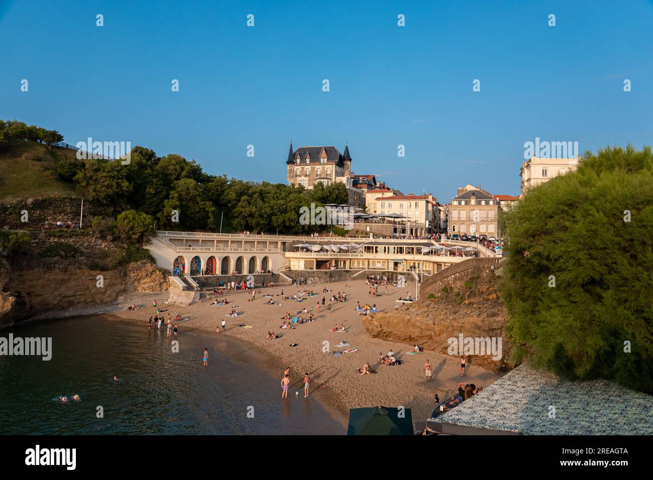La spiaggia di Biarritz "Plage du Port Vieux" è piena di persone che fanno il bagno e prendono il sole in un pomeriggio d'estate. Foto Stock