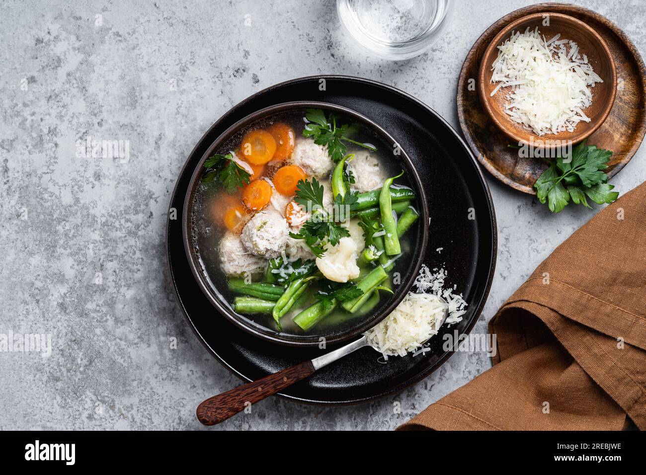 Zuppa di polpette, minestrone con verdure di stagione ed erbe aromatiche, servita con parmigiano, sano cibo estivo di stagione, vista dall'alto Foto Stock