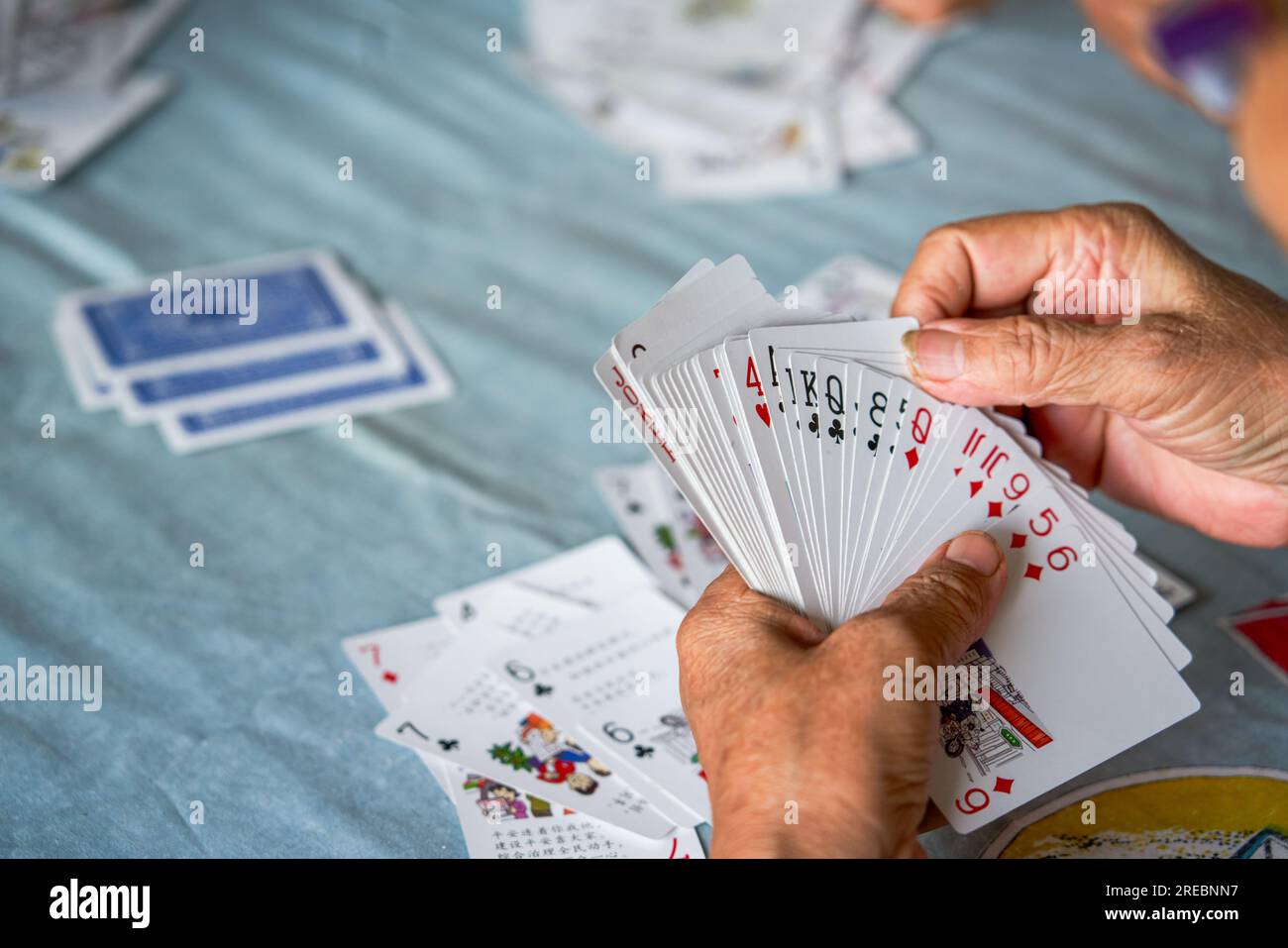 Un gruppo di anziani si siede e gioca a carte da poker Foto Stock