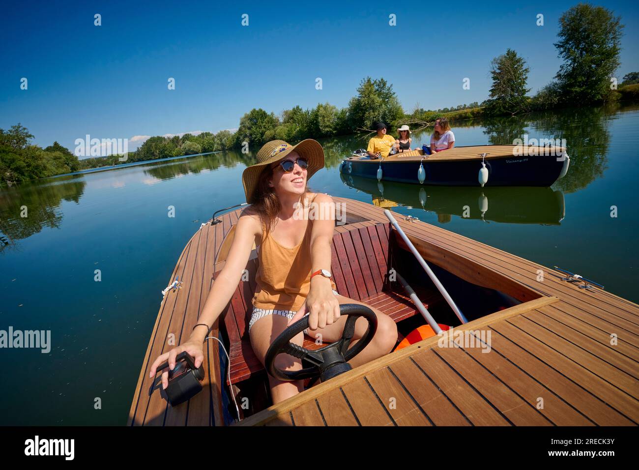 Barca elettrica, gruppo di amici in una gita in barca sul Canal Charles Quint e sul fiume Doubs a Dole (Francia nord-orientale). Giovane donna su una barca tr Foto Stock