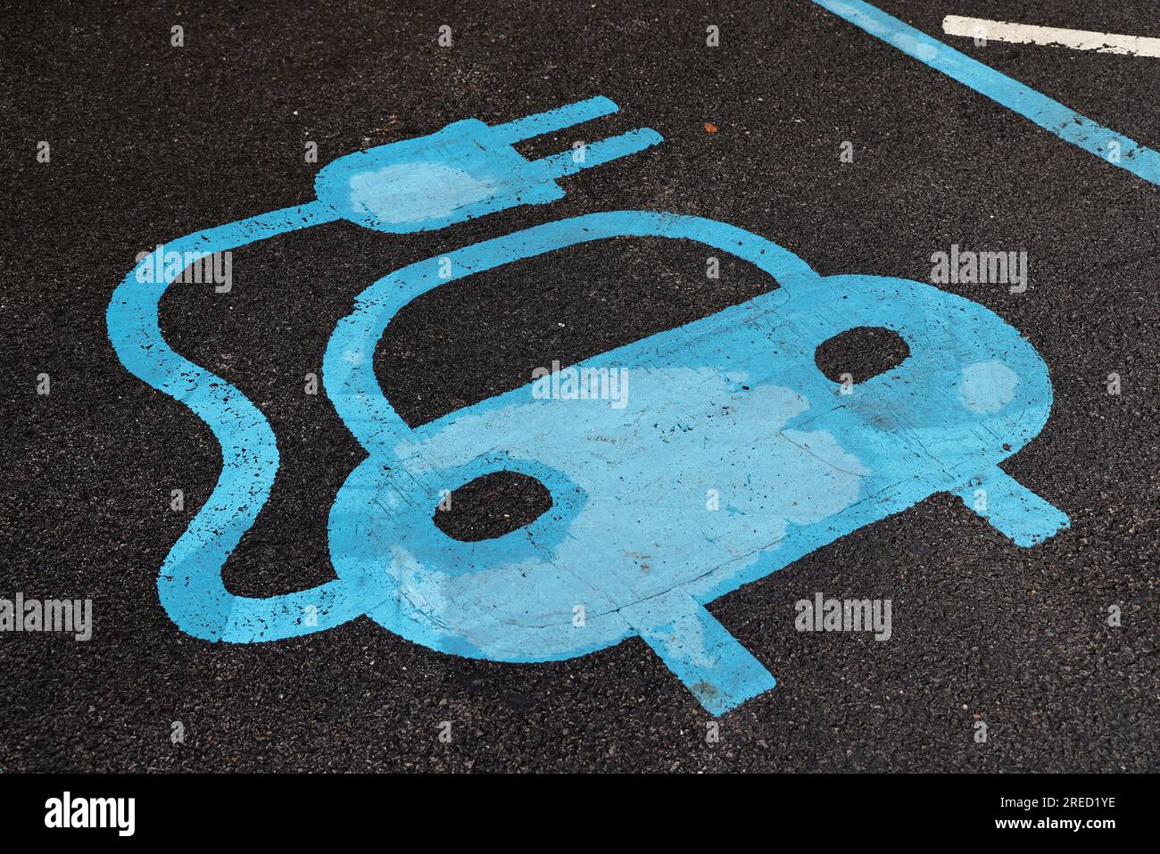 Trasporti, strada, auto, cartello blu dipinto sul parcheggio per il punto di ricarica delle auto elettriche. Foto Stock