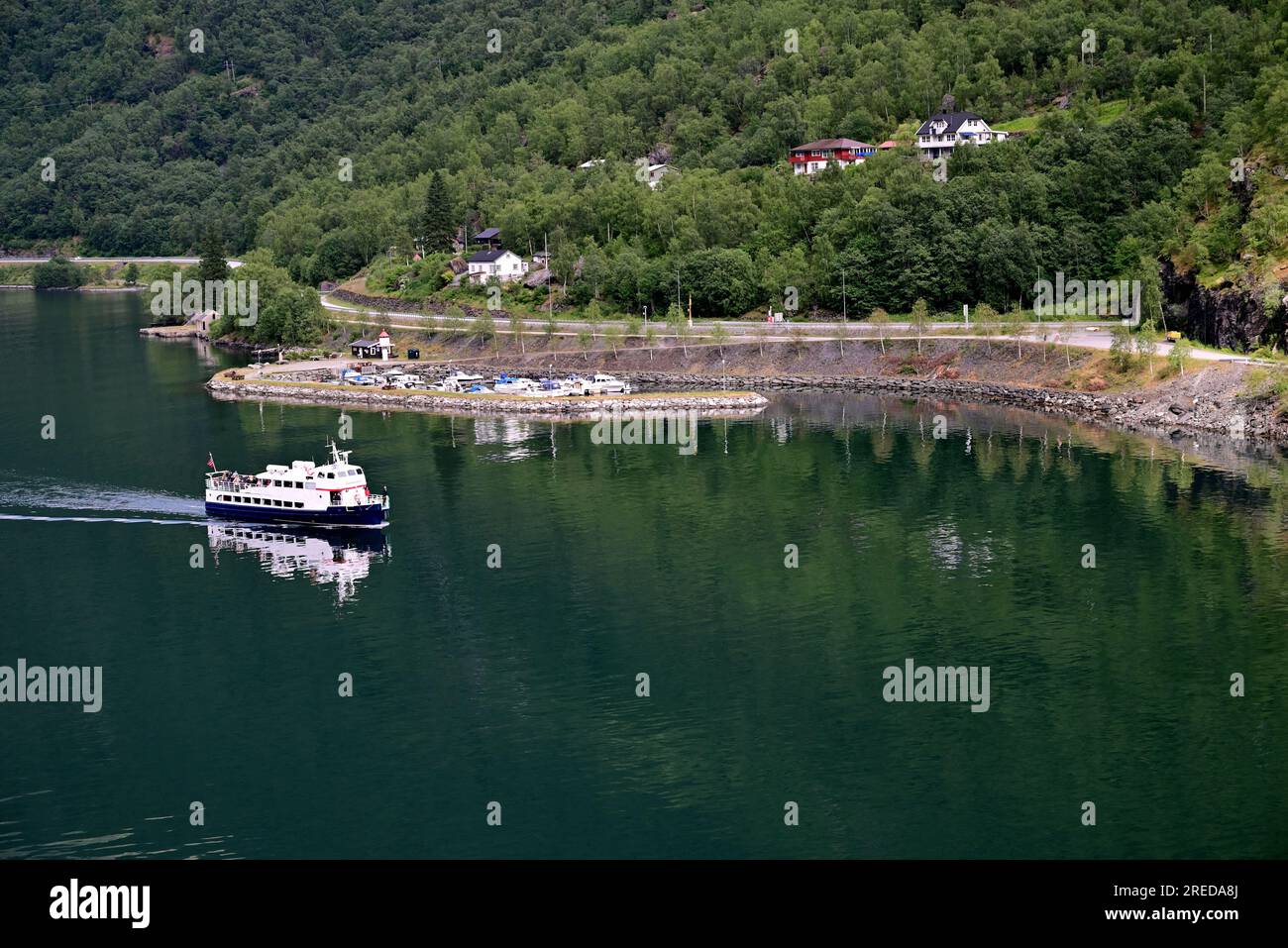 La strada europea E16 segue la riva dell'Aurlandsfjorden a Flam prima di entrare nel tunnel Fretheim di 1360 m intorno alla fine del fiordo. Foto Stock