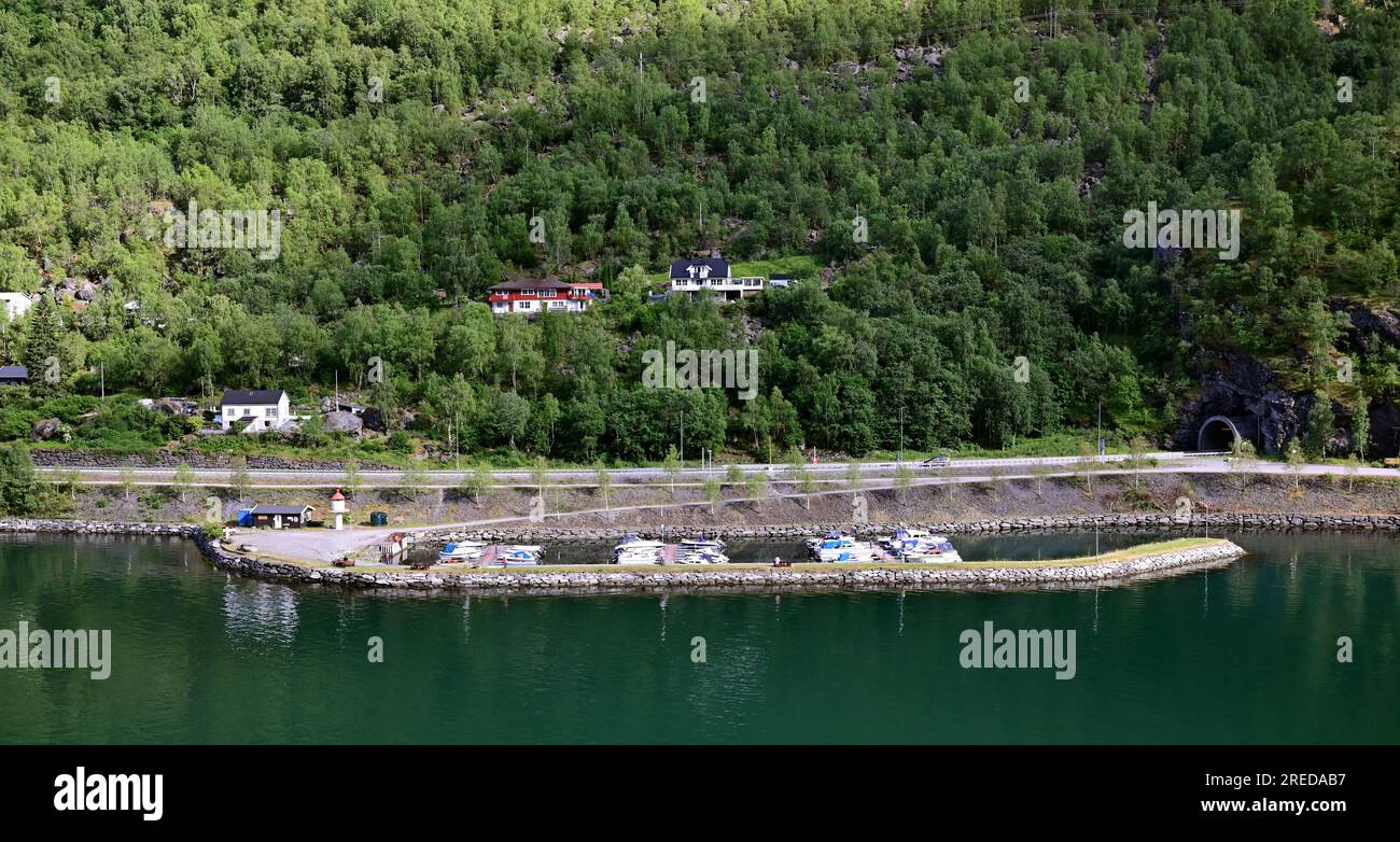 La strada europea E16 segue la riva dell'Aurlandsfjorden a Flam prima di entrare nel tunnel Fretheim di 1360 m intorno alla fine del fiordo. Foto Stock