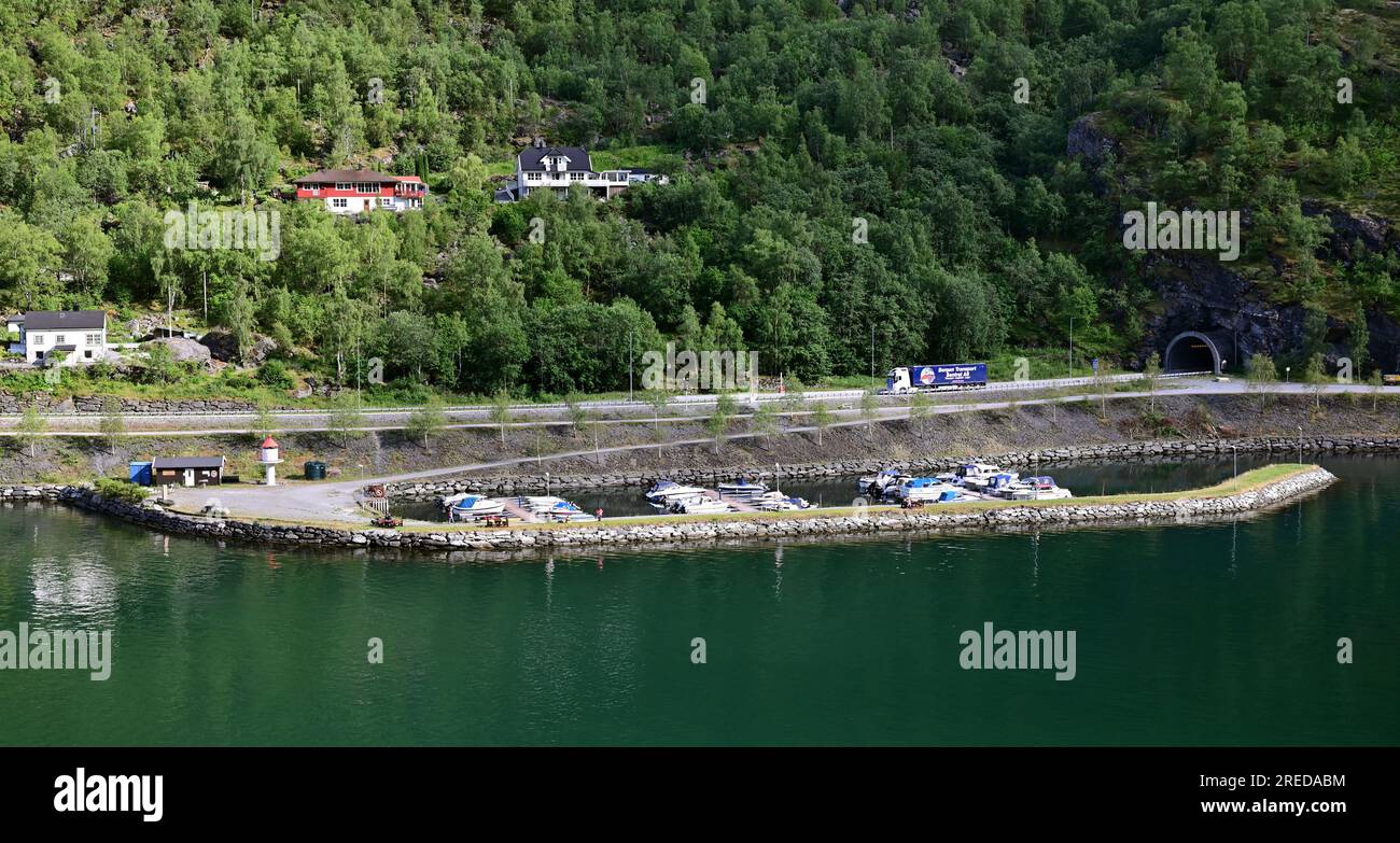 La strada europea E16 segue la riva dell'Aurlandsfjorden a Flam prima di entrare nel tunnel Fretheim di 1360 m intorno alla fine del fiordo. Foto Stock