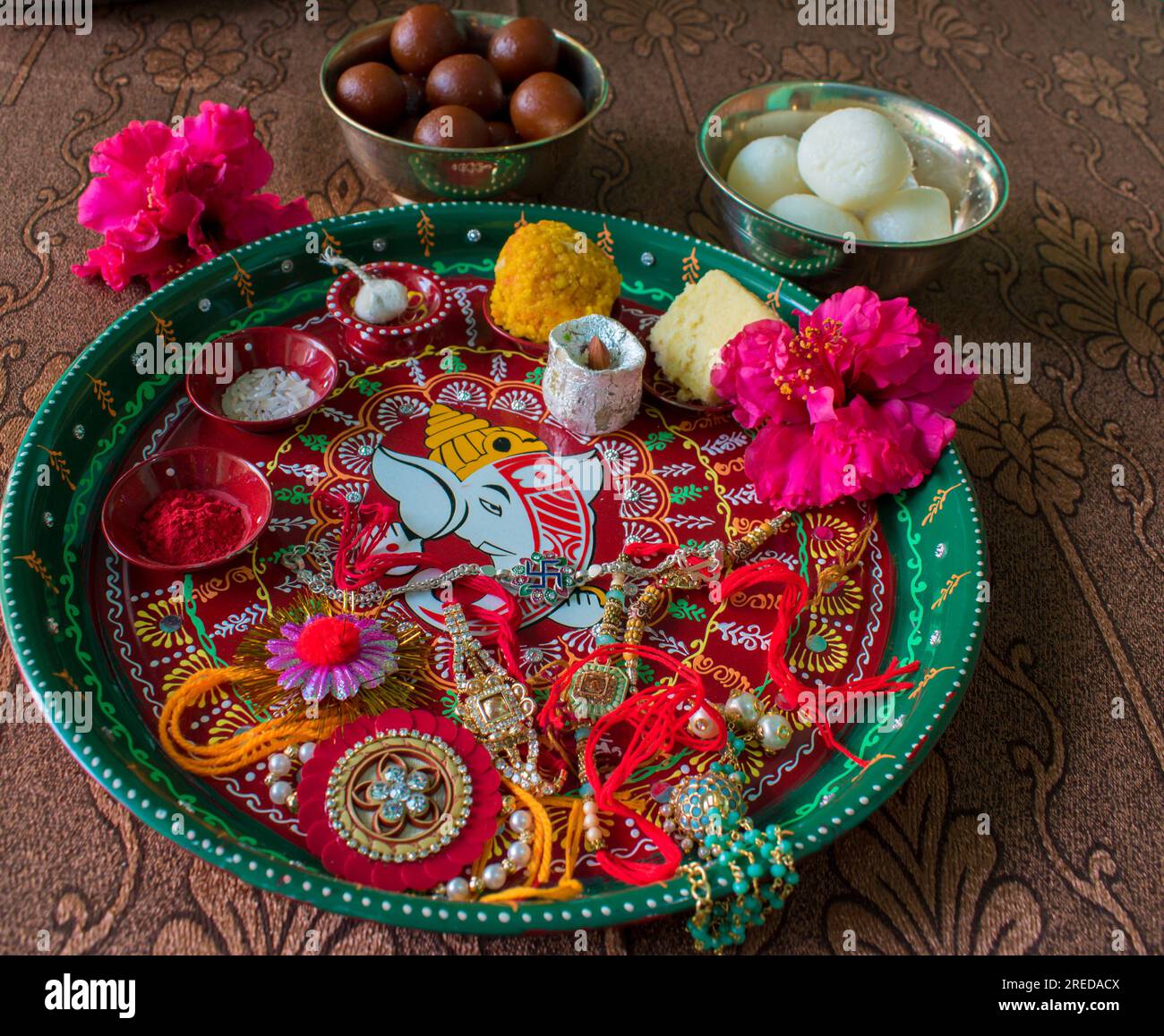 Piatto di pooja decorato o thali contenente chicchi di riso, kumkum, ladoo, gulab jamun, rakhi, Flower and diya per rakhi o raksha bandhan festival dell'India Foto Stock