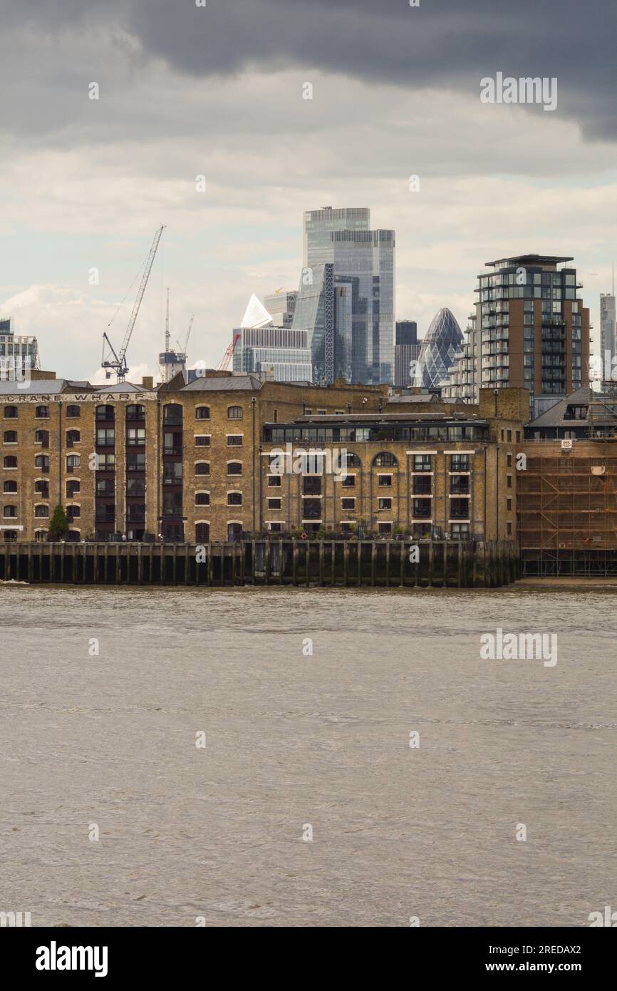 I grattacieli del Central Business District e lo skyline di Londra si sono sovrapposti al fiume Tamigi a Wapping, Londra, E1, Inghilterra, Regno Unito Foto Stock