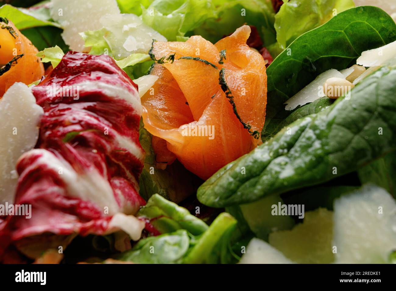 Insalata deliziosa con salmone, parmigiano, pomodori e verdure miste Foto Stock