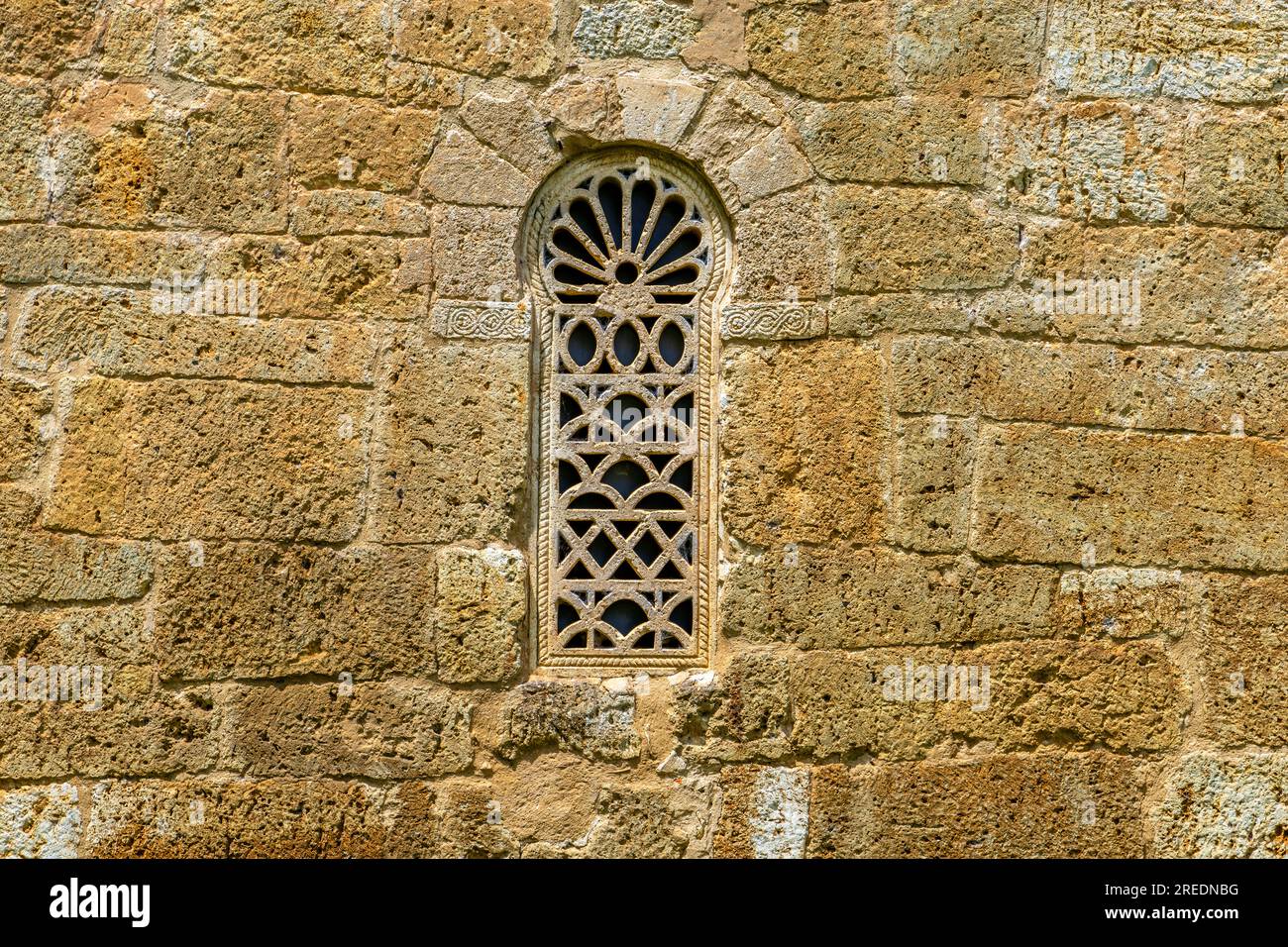 Finestra keyhole nel muro. Esterno della chiesa visigotica di San Juan Bautista, fondata nel 661 d.C. Situato nella piccola città di Venta de Baños nel Cerrato Foto Stock