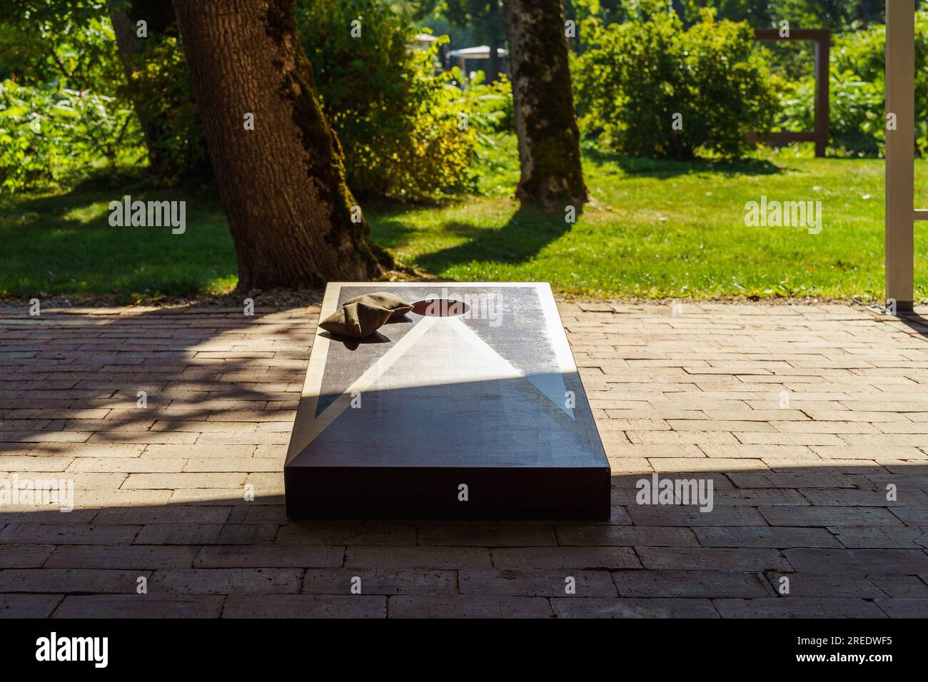 Tavola e sacchetti di fagioli per giocare a Cornhole nel cortile della casa in estate Foto Stock