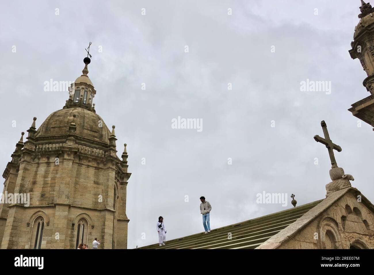 Vista sul tetto di una delle torri della cattedrale di Santiago e croce in pietra su un agnello di granito del dio agnus dei Santiago de Compostela Galizia Spagna Foto Stock
