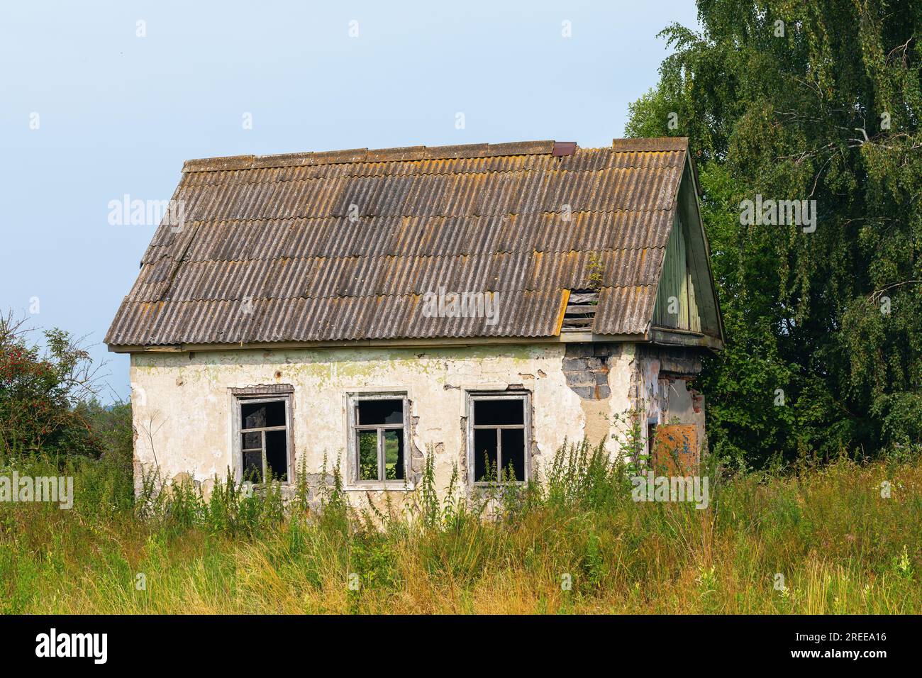Vecchia casa del villaggio abbandonata e terreno nel campo Foto Stock