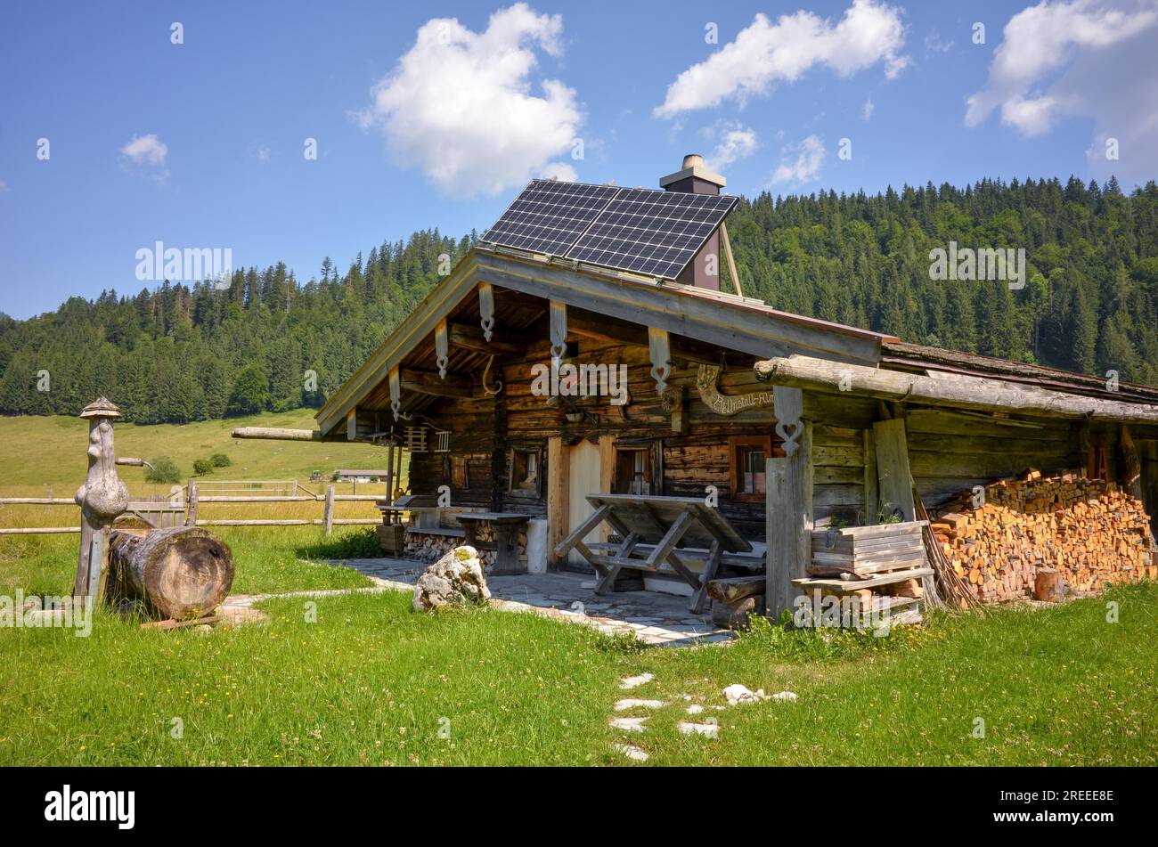 Rifugio alpino con pozzo e pannelli solari sul Roetelmoosalm, Chiemgau, Baviera, Germania Foto Stock