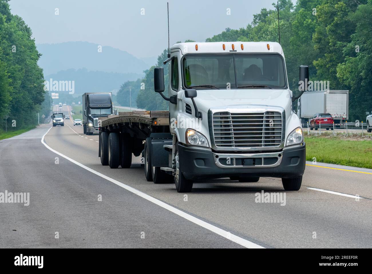 Immagine orizzontale di un diciotto ruote bianche su una nebbiosa superstrada del Tennessee. Foto Stock