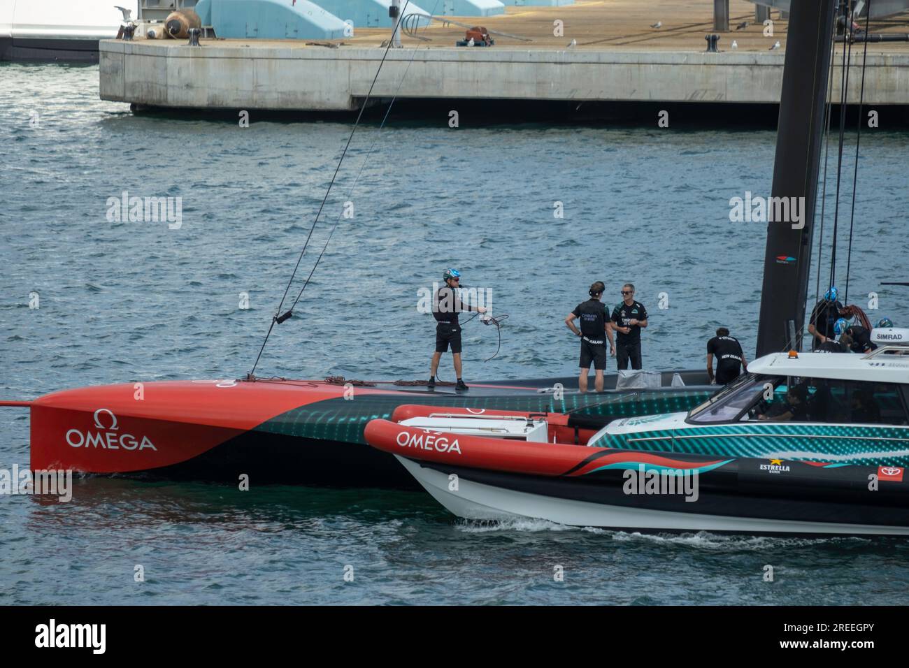 Barcellona, Spagna. 26 luglio 2023. L'equipaggio della nave a vela Emirates Team New Zealand ha assistito all'addestramento nel porto di Barcellona. Le strutture della competizione velica American's Cup Barcelona iniziano ad essere visibili nel porto di Barcellona. Alcune delle basi nautiche delle squadre che parteciperanno alle più importanti competizioni sportive veliche mostrano già le bandiere dei loro paesi. Alcune squadre si allenano già nelle acque del porto di Barcellona. (Foto di Paco Freire/SOPA Images/Sipa USA) credito: SIPA USA/Alamy Live News Foto Stock