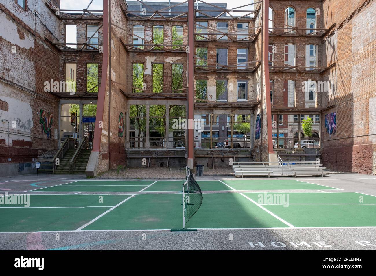 Campo ricreativo da pallacanestro nel centro di Louisville, Kentucky, vista del campo verde vuoto all'interno di una facciata in mattoni abbandonata. Foto Stock